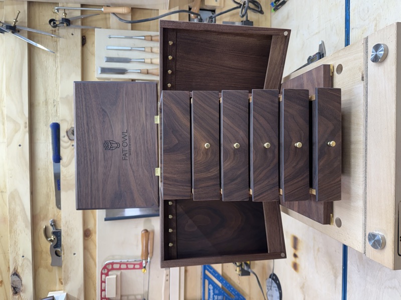 Walnut jewelry cabinet with its lid raised and side doors open